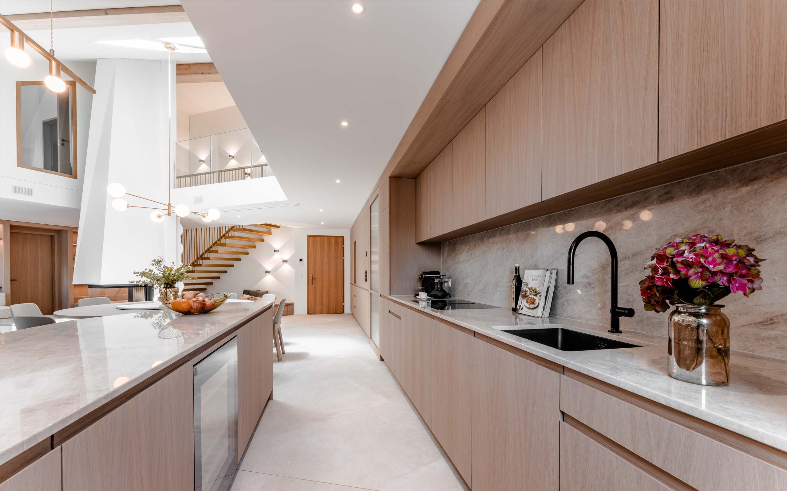 Eigentumswohnung. Ansicht Schreinerküche aus Eiche und Marmor. ASA Andermatt Swiss Alps - MACH Architektur.